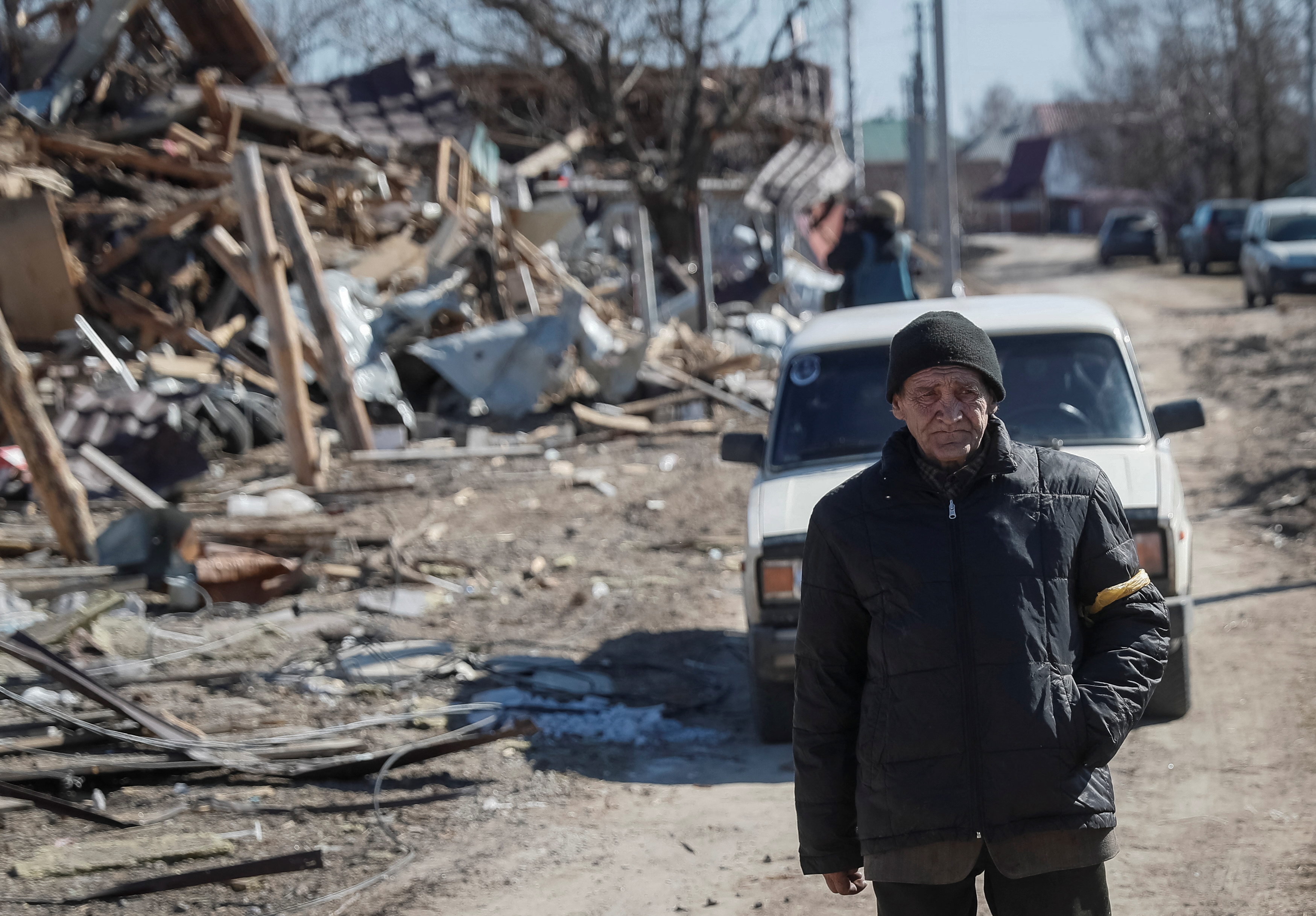 Un residente cammina in un villaggio distrutto in Ucraina