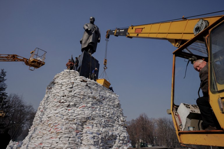 People pile up sand bags around monument to Ukrainian poet Taras Shevchenko.