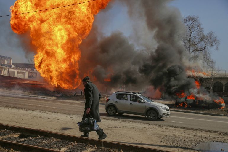 A man walks past a fire after a shelling, as Russia's attack on Ukraine continues, in Kharkiv