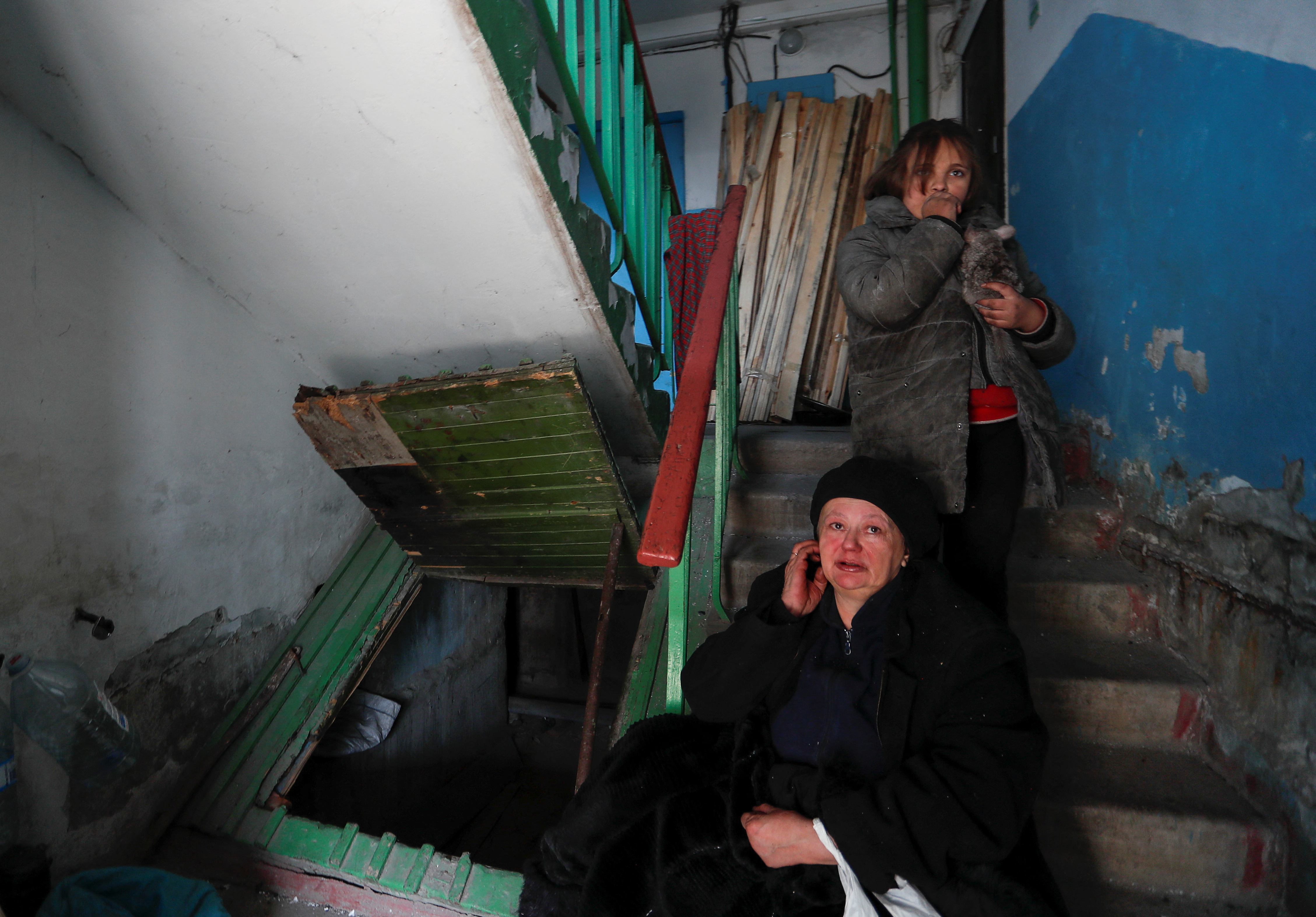 Una donna e sua nipote sulle scale del loro condominio a Mariupol assediata mentre reagiscono ai bombardamenti