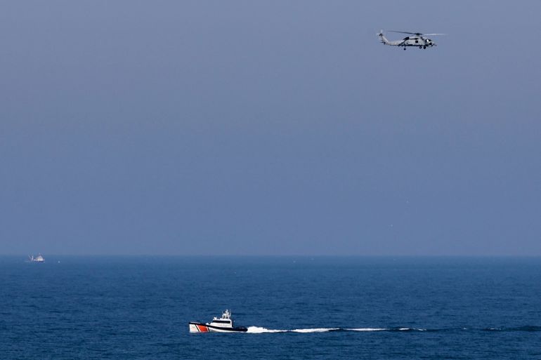 A Turkish Navy helicopter flies over a coast guard boat in Istanbul