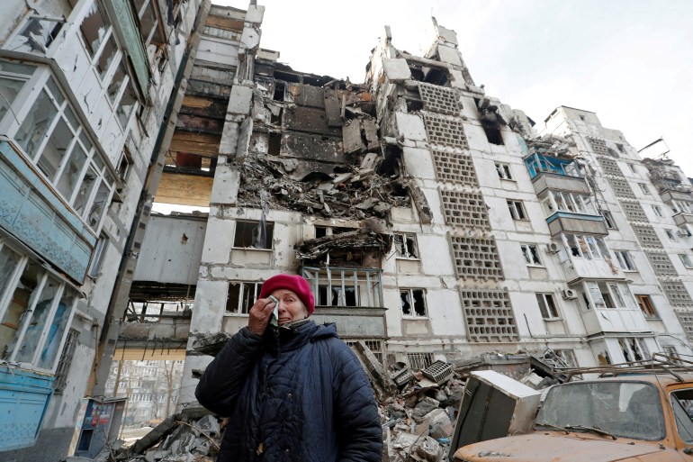 Local resident Valentina Demura, next to the building where her apartment, destroyed during Ukraine-Russia conflict, is located in the besieged southern port city of Mariupol