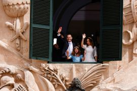 Malta's Prime Minister Robert Abela, his wife Lydia Abela and their daughter, Giorgia Mae, wave to supporters from a window of the office of the prime minister at Auberge de Castille