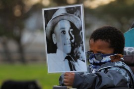 A boy holds a photograph of Emmett Till, a 14-year-old who was lynched in 1955 [File: Brian Snyder/Reuters]