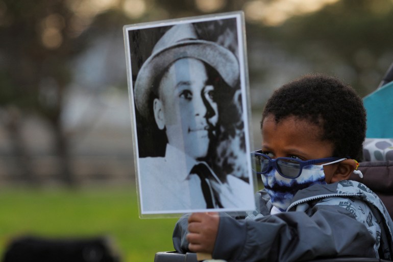 Four-year-old Senty Banutu-Gomez holds a photograph of Emmett Till, a 14-year-old Black boy who was lynched in 1955, at a vigil on the one year anniversary of the murder of George Floyd while in Minneapolis police custody.
