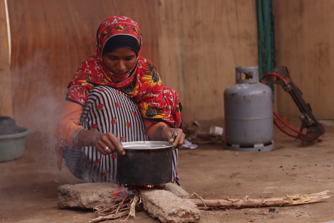 Ghadam Salem, a mother of three, is cooking boiled potatoes that she sells thanks to firewood.