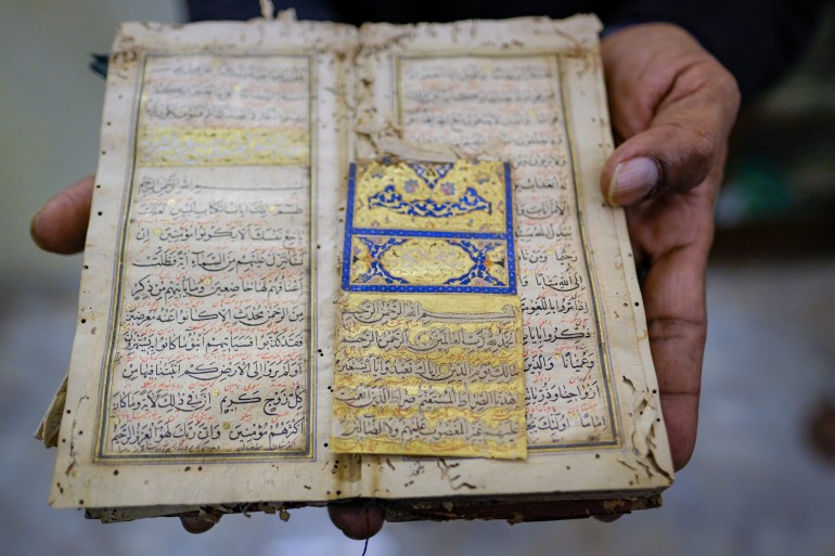 Emran's hand hold open an illuminated Quran several hundred years old