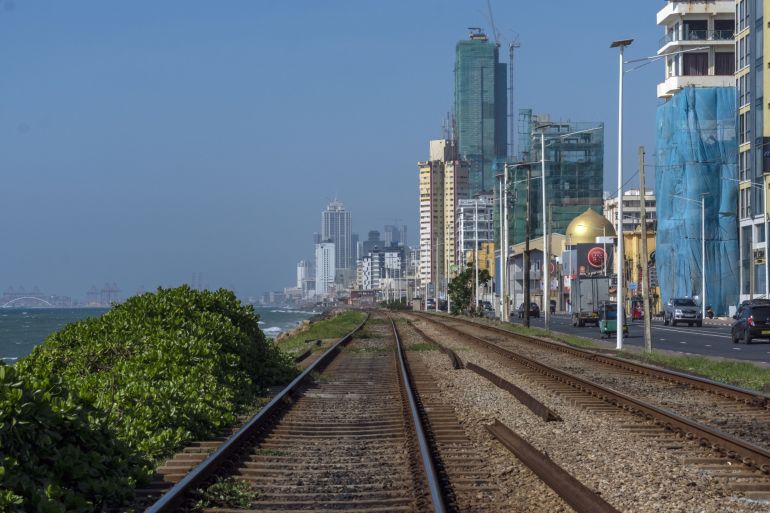 Traffic travels alongside rail tracks along Marine drive in Colombo, Sri Lanka