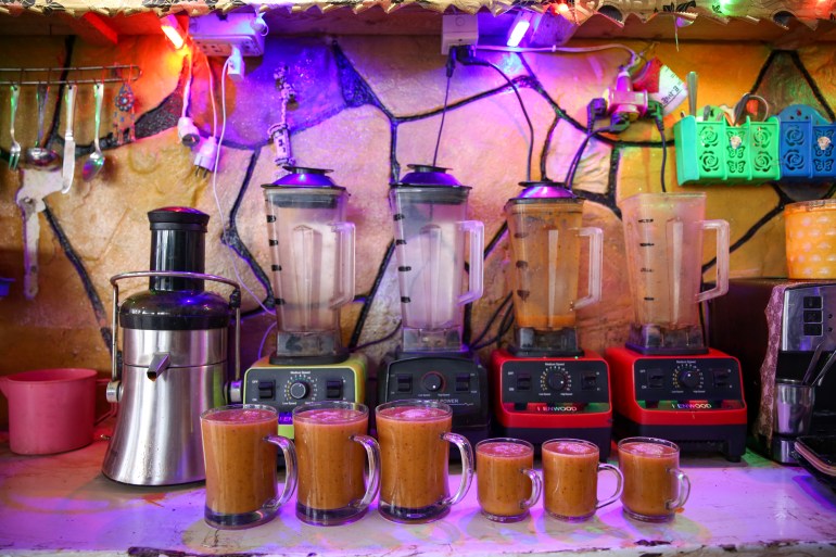 Four blenders and an electric juicer lined up on a counter at Daaboul's juice shop