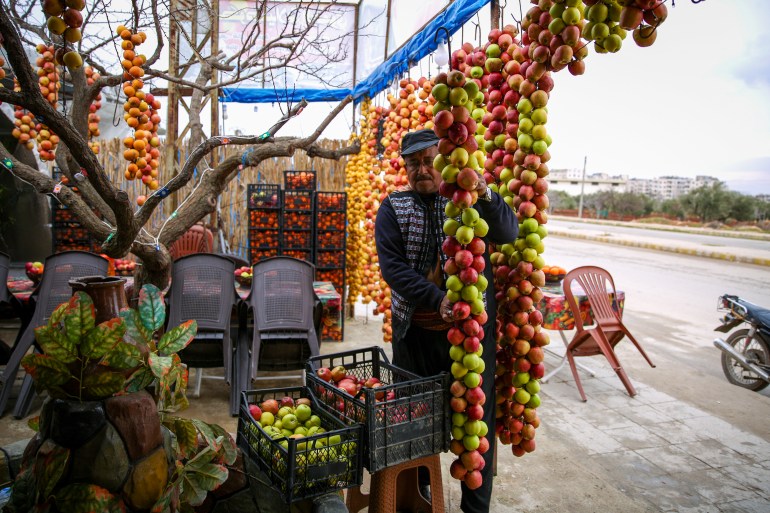 Daaboul is shown in front of his shop hanging apples up on strings to dry.