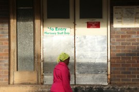 In this Jan. 9, 2019, photo, a woman walks past the mortuary entrance where a family collected the body of their son who died at Parirenyatwa Hospital in Harare, Zimbabwe. The family who blamed the death of their son on the doctors strike said they were devastated. A doctors strike in Zimbabwe has crippled a health system that was already in intensive care from neglect.It mirrors the state of affairs in a country that was full of promise a year ago with the departure of longtime leader Robert Mugabe but now faces economic collapse.