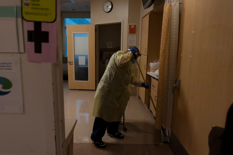 Environmental technician Gerardo Velazquez cleans a room after a COVID-19 patient was transferred to an intensive care unit