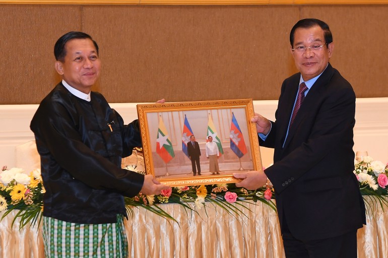 Min Aung Hlaing (left in traditional longyi) and Hun Sen show off a souvenir photo of their meeting