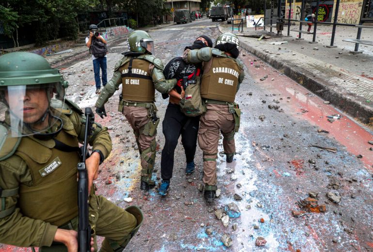 Armed Chilean police detain an anti-government protester in Santiago, Chile, in 2019. 