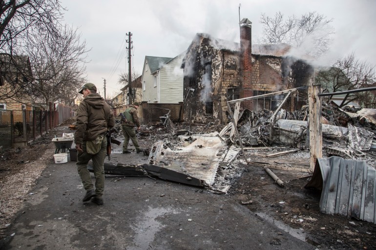 Ukrainian servicemen walk at fragments of a downed aircraft seen in in Kyiv