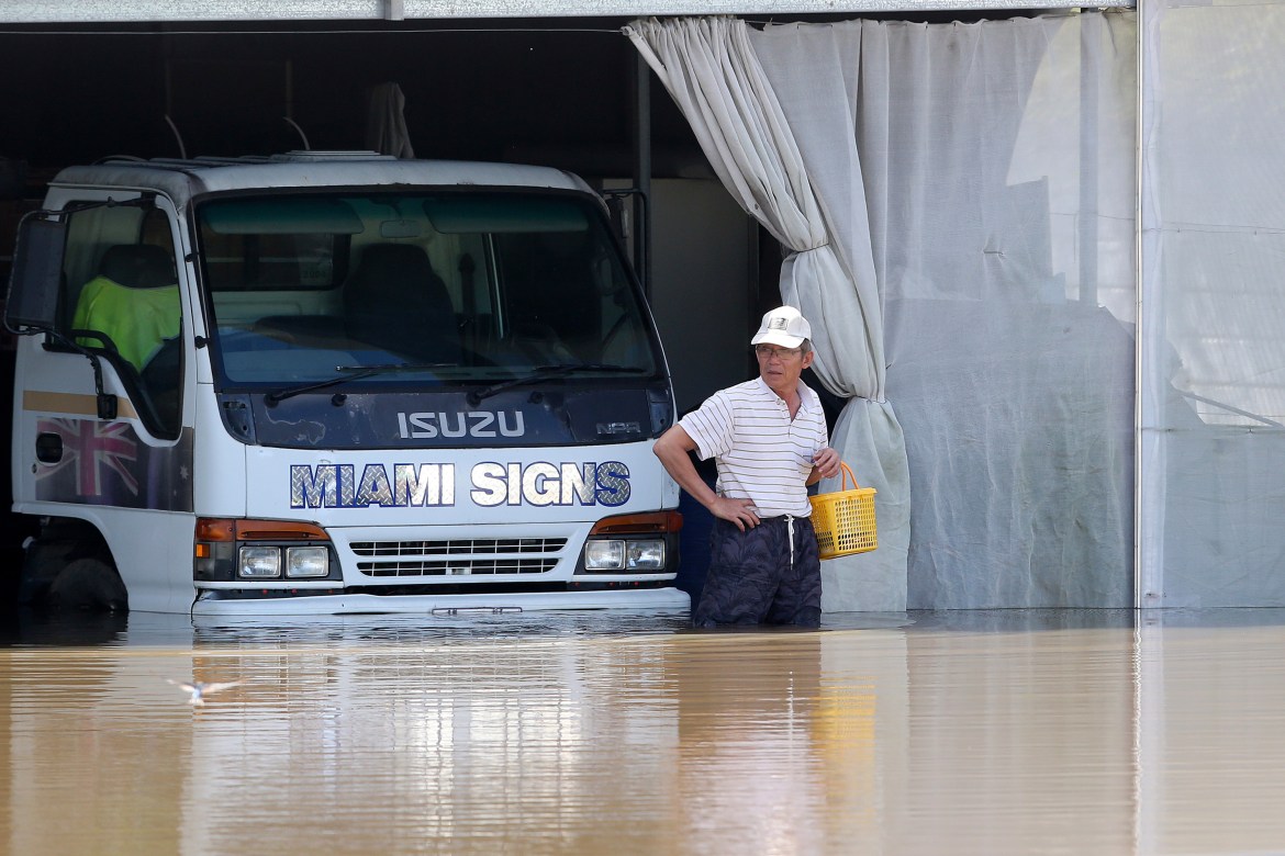 A man inspects the damage at a farm in Logan