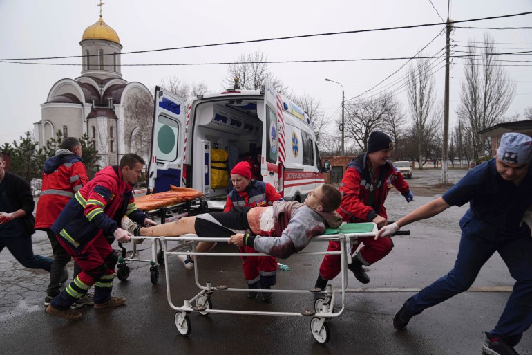 Paramedics are see moving a patient in Mariupol