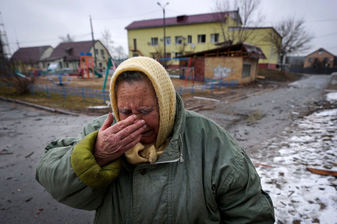 A woman cries outside houses damaged by a Russian airstrike, according to locals, in Gorenka
