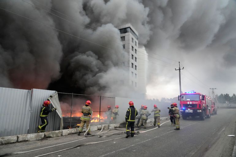 Firefighters work to extinguish a fire at a damaged logistics center after shelling in Kyiv, Ukraine