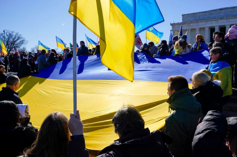 Protesters hold Ukrainian flags.