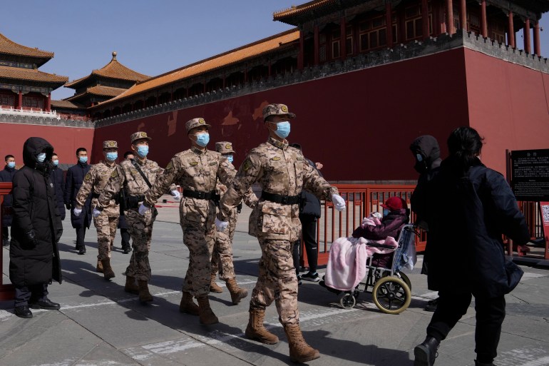 Фотография китайских военизированных полицейских, марширующих мимо Запретного города.