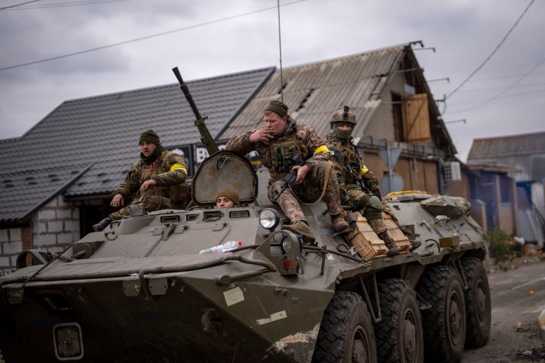 A photo of Ukrainian soldiers driving an armored military vehicle.