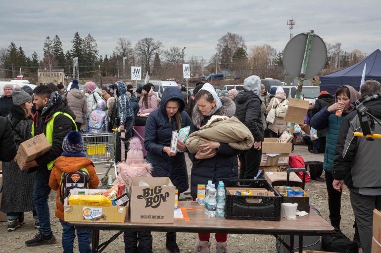 Women refugees look for baby food after they arrived at the border crossing in Medyka, Poland