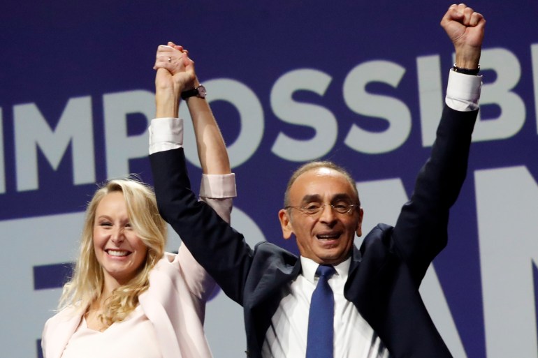 French far-right presidential candidate Eric Zemmour, right, holds Marion Marechal's hand as he arrives on stage during a campaign rally