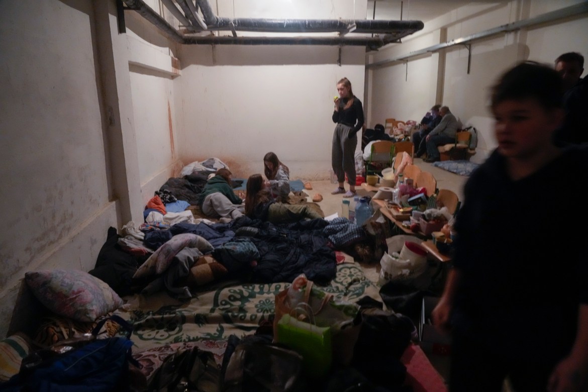 People hide from Russian artillery shelling in a school basement in the village of Horenka close to Kyiv