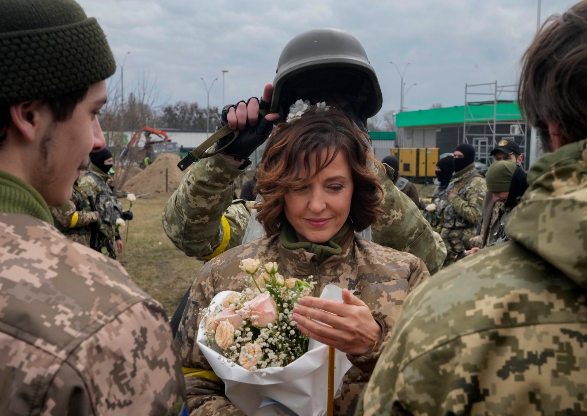 A soldier holds a helmet as a wedding crown during the wedding ceremony for members of the Ukrainian Territorial Defence Forces Lesia Ivashchenko and Valerii Fylymonov, at a checkpoint in Kyiv