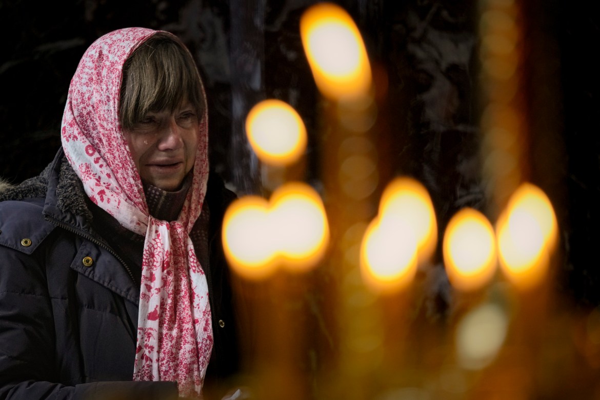 A woman cries during a religious service at the St Volodymyr's Cathedral in Kyiv, Ukraine