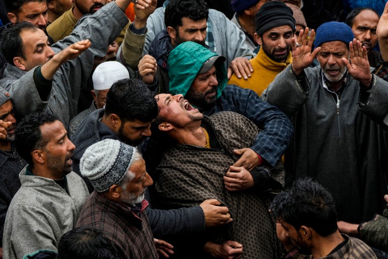 Family members mourn near the dead body of Rafia Nazir, a young Kashmiri woman killed in grenade attack during her funeral in Srinagar