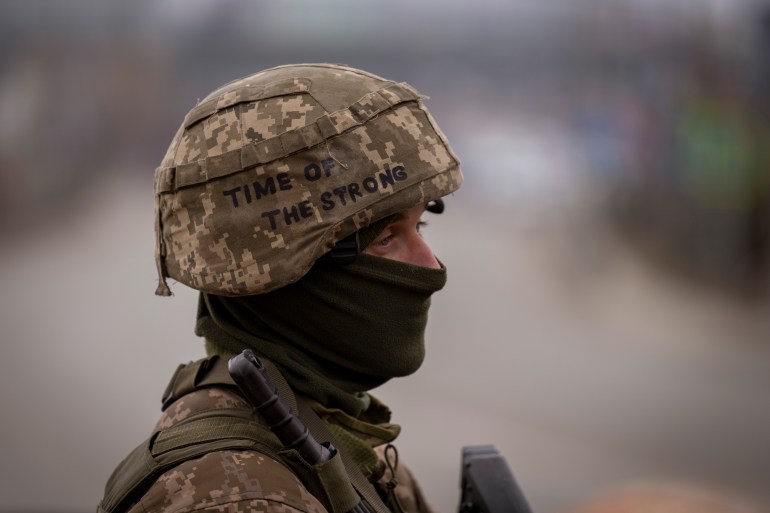 A Ukrainian soldier is seen standing guard on the outskirts of Kyiv