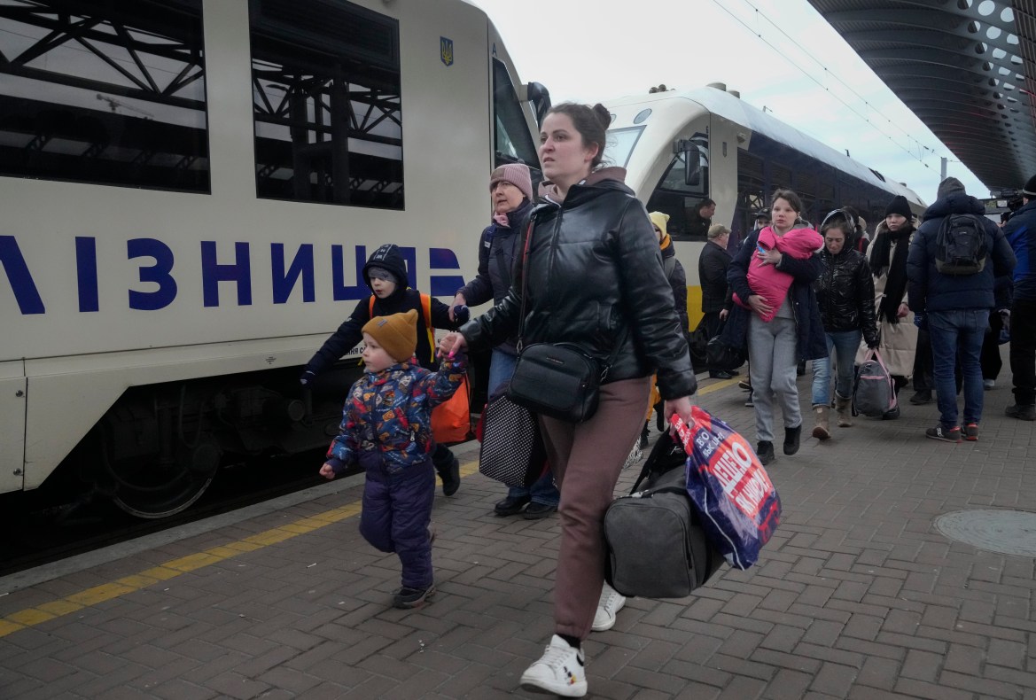 Parents accompany children and teenagers as they board a train after leaving Kyiv's Central Children's Hospital, following its evacuation, in Kyiv,