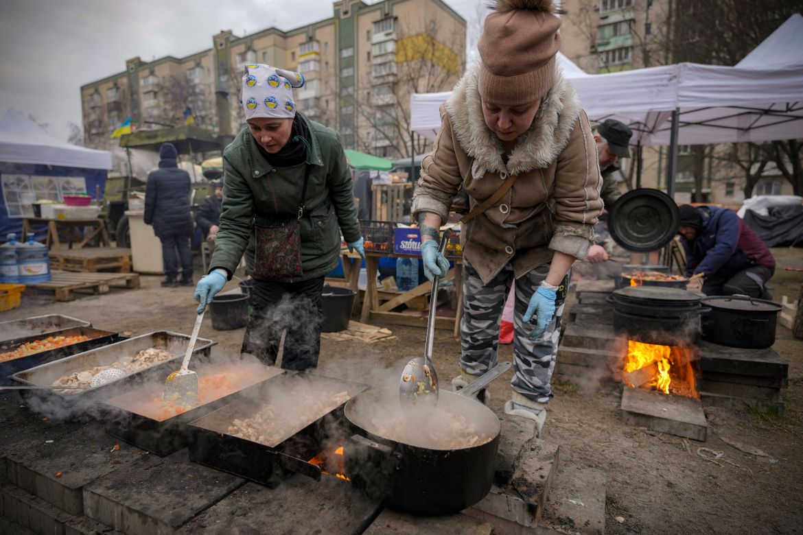 People cook outdoors for Ukrainian servicemen and civil defense members serving in Kyiv