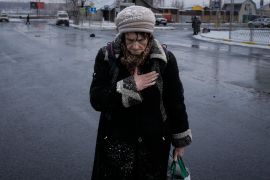 An elderly lady pauses after fleeing Irpin, on the outskirts of Kyiv, Ukraine, Tuesday, March 8, 2022. Demands for ways to safety evacuate civilians have surged along with intensifying shelling by Russian forces, who have made significant advances in southern Ukraine but stalled in some other regions. Efforts to put in place cease-fires along humanitarian corridors have repeatedly failed amid Russian shelling. (AP Photo/Vadim Ghirda)