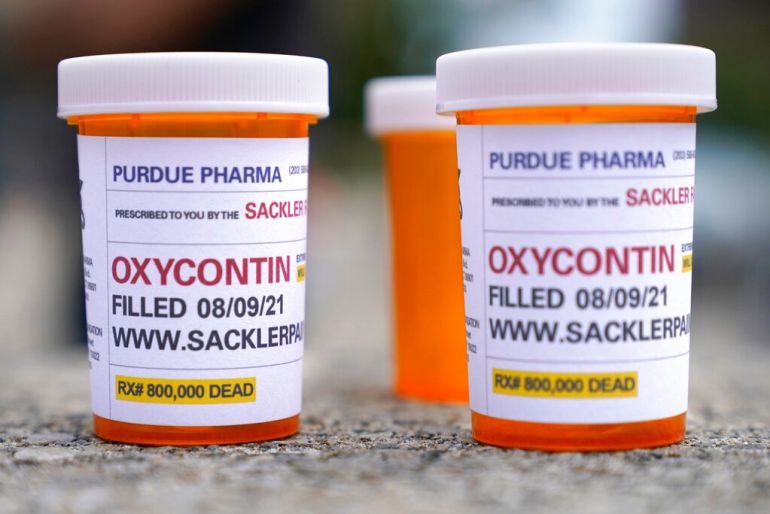   Fake pill bottles with messages about OxyContin maker Purdue Pharma are displayed during a protest outside the courthouse where the bankruptcy of the company is taking place in White Plains, New York.