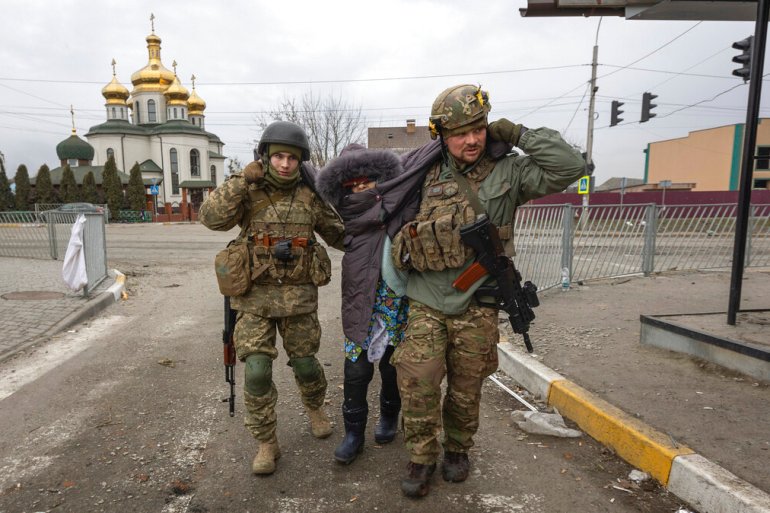 Ukrainian servicemen help evacuate an elderly woman, in the town of Irpin, Ukraine on March 6.