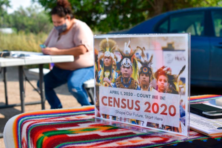  A sign promoting Native American participation in the U.S. census is displayed as Selena Rides Horse enters information into her phone on behalf of a member of the Crow Indian Tribe in Lodge Grass, Montana.
