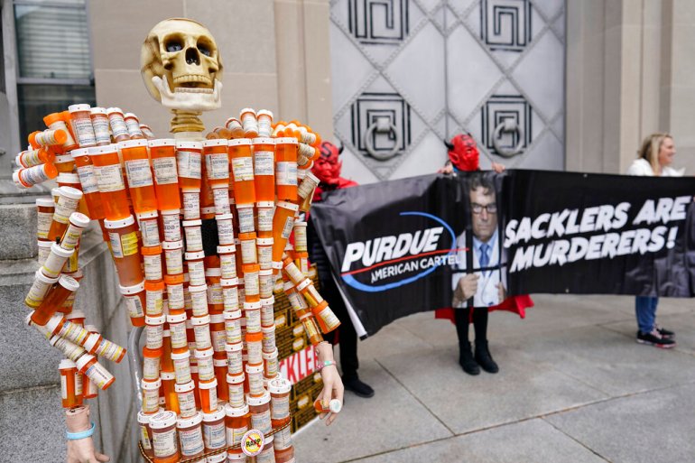 Pill Mann" made by Frank Huntley of Worcester, Mass., from his opioid prescription pill bottles, is displayed during a protest by advocates for opioid victims outside the Department of Justice.