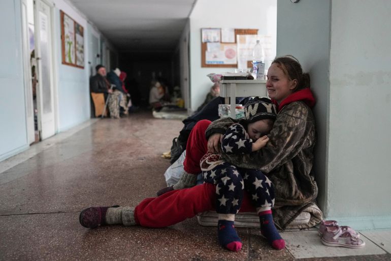 A woman cries as she hugs her child in a corridor of a hospital in Mariupol, eastern Ukraine.