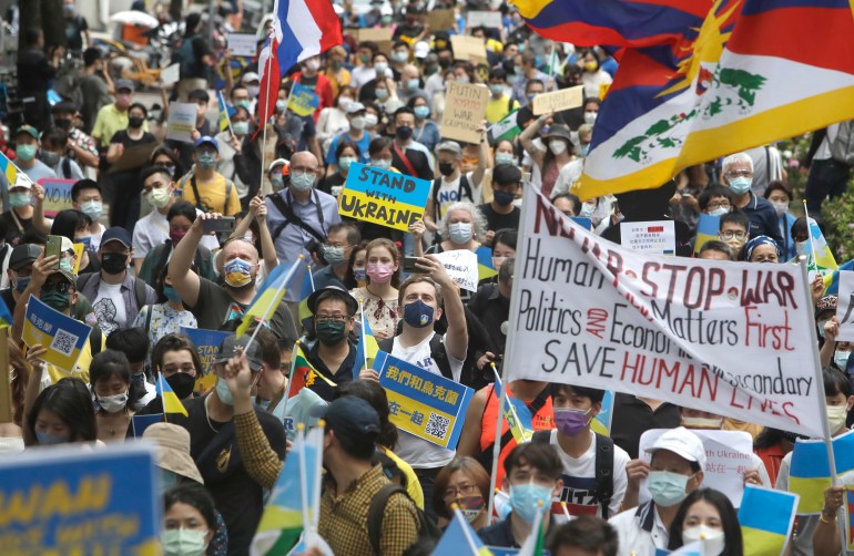 Crowds of people march in support of Ukraine waving the country's blue and yellow flag during a rally in Taipei on March 13