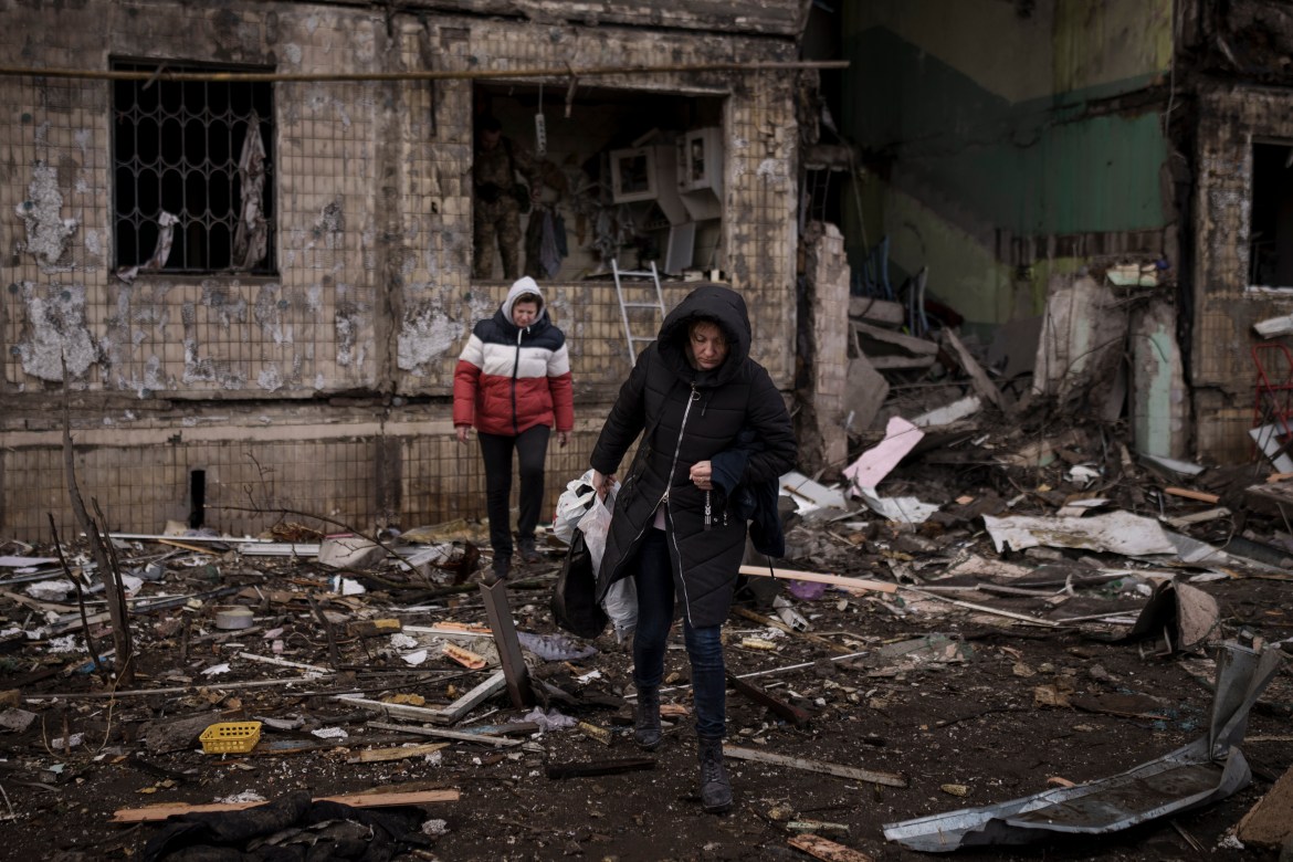 Residents remove their belongings from a destroyed building after it was hit by artillery shelling in Kyiv