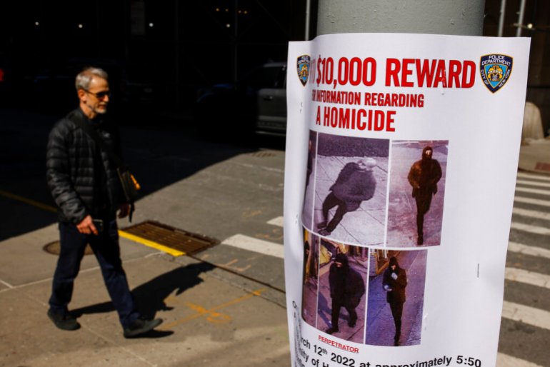     Pedestrians walk past a bulletin posted by the NYPD near where a homeless person was killed a few days earlier in lower Manhattan.