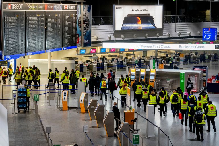 Security employees who control the flow of passengers and luggage walk through a terminal at the airport during a one day strike in Frankfurt
