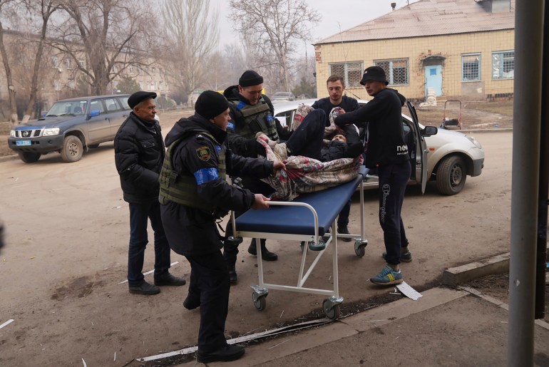Voluntarios y militares ucranianos transportan a un herido 