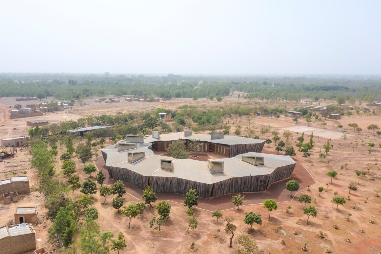 he Lycée Schorge in Burkina Faso sits in a dry and unforgiving landscape and is designed with local clay with a high roof to protect from rain and keep the building cool