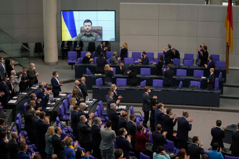 Members of the German parliament Bundestag give Ukraine President Volodymyr Zelenskyy a standing ovation before he speaks in a virtual address to the parliament at the Reichstag Building in Berlin, Germany