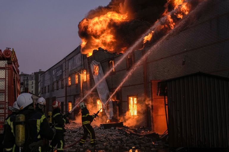 Ukrainian firefighters extinguish a blaze at a warehouse after a bombing in Kyiv, Ukraine.