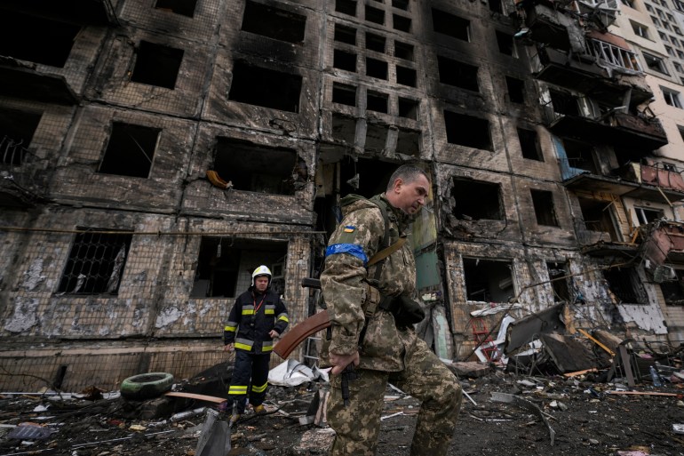 Ukrainian soldiers and firefighters search in a destroyed building after a bombing attack in Kyiv, Ukraine, Monday, March 14, 2022. (AP Photo/Vadim Ghirda, File)